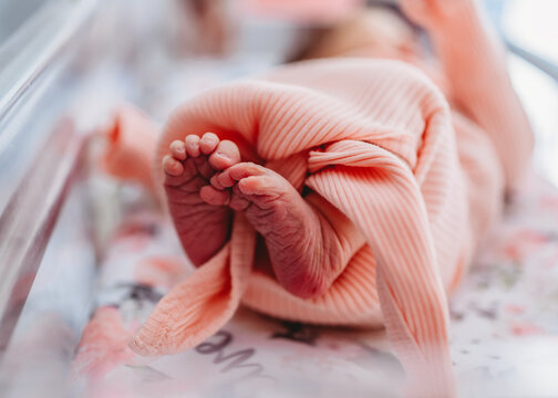 Close up of newborn baby girl's tiny feet and toes