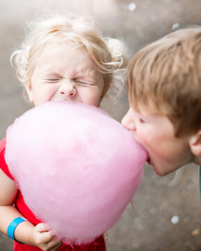 Kids sharing cotton candy at carnival