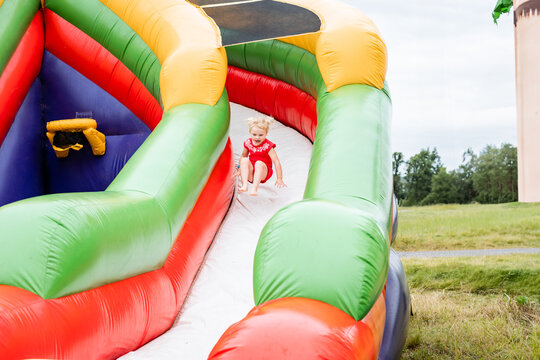 Young child bouncing down inflatable slide