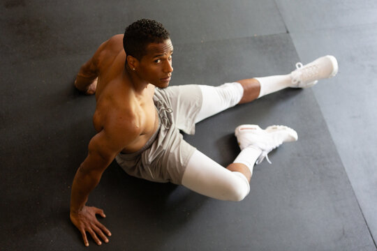 Fit Shirtless Man Sitting on Gym Floor