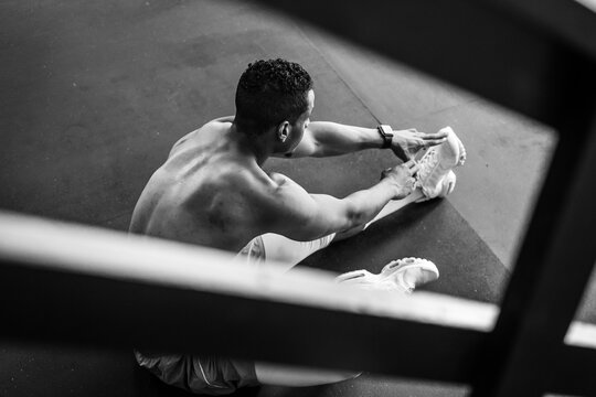 B&W Fit Shirtless Man Stretching on Gym Floor