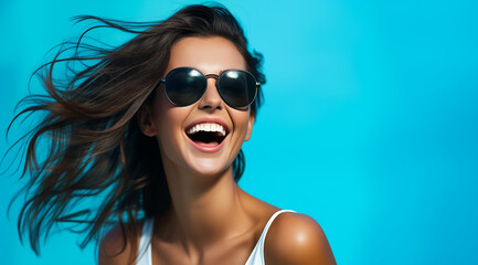 Une belle femme brune, heureuse et souriante portant des lunettes de soleil sous un beau ciel bleu d'été, image avec espace pour texte. - obrazy, fototapety, plakaty