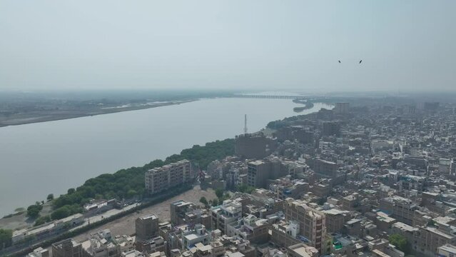 Drone flies over indus river and the city of Sukkur tall houses and a wide river