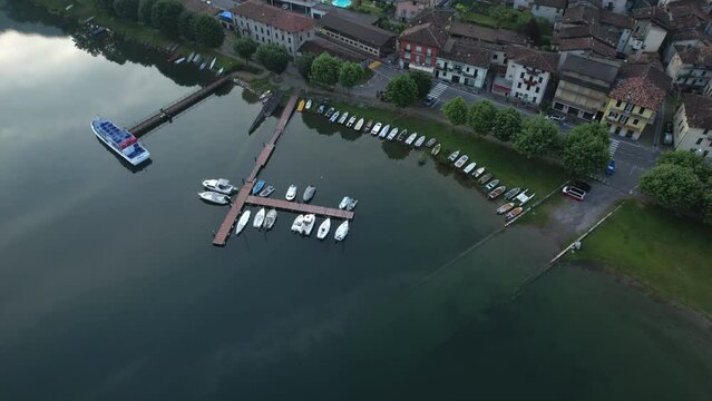 Top view of small boats docked by a promenade in a picturesque lakeside town. Crone, Italy, Lake Idro