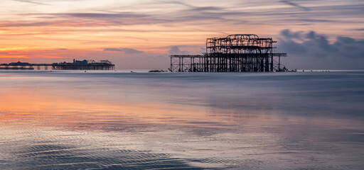 Dawn low tide at Brighton west pier looking east with the Palace Pier in the background on the east...