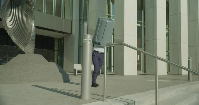 Clumsy man tripping into trash bin and stumbling down stairs - wide, tracking shot