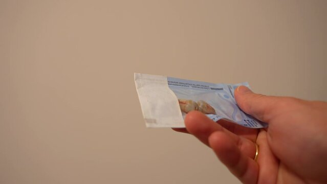 Unrecognisable adult holding a bag of extracted blooded wisdom teeth, close up