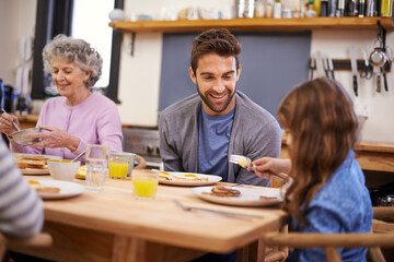Love, breakfast and family in a kitchen with pancakes, eating or bonding at a table together. Food,...