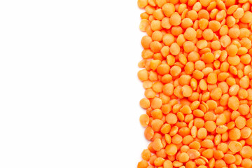 Uncooked red lentils border on white background. Copy space for text. Top view