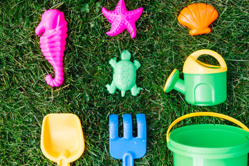 childhood and summer concept - close up of sand toys kit on green lawn or grass - 767711946