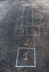leisure games and childhood concept - close up of hopscotch chalk drawing on asphalt pavement - 767712199