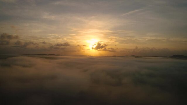 Left to right aerial view of the sunrise about low cloud