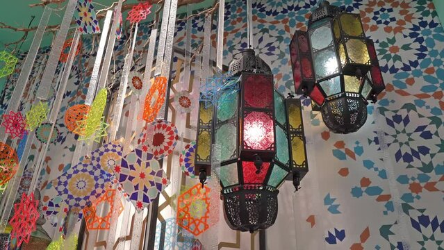 Close-up view of the colorful lanterns with various types of geometric shapes hanging with the geometric background.