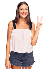 Young hispanic woman wearing casual clothes showing and pointing up with fingers number two while smiling confident and happy.