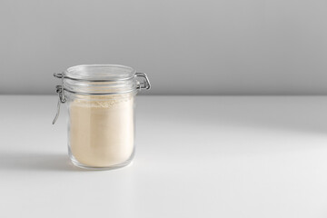 food storage, eating and cooking concept - jar with almond flour on white background
