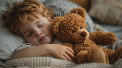 The little boy sleeps with a big teddy bear