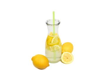 Woda smakowa z cytryną w szklanym dzbanku ze słomką, obok żółte świeże cytrusy