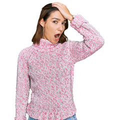 Young caucasian girl wearing wool winter sweater surprised with hand on head for mistake, remember...
