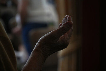 Human hand praying and rising worshiper at Church.
