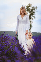 The girl and her mother are walking in a field of lavender, when all of a sudden