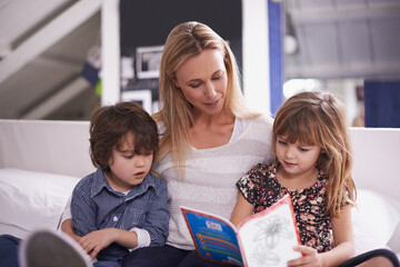 Reading, mother and children on couch with book for bonding, teaching and learning together in home. Woman, son and daughter relax on sofa with storytelling, smile and happy family in living room
