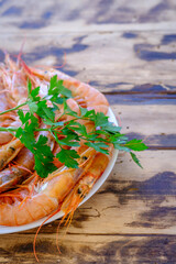 Raw prawns with a sprig of parsley decorating the platter.