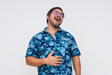 Content middle aged man in a floral Hawaiian shirt, rubbing his belly indicating fullness and satisfaction, isolated on white.