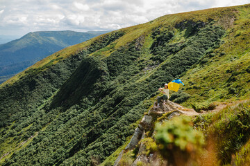 A woman on the mountains with a ukrainian flag