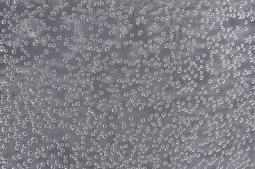 Many small bubbles in the water. Abstract gray background with air bubbles