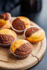 Close Up of a Muffins on cutting board on black table.