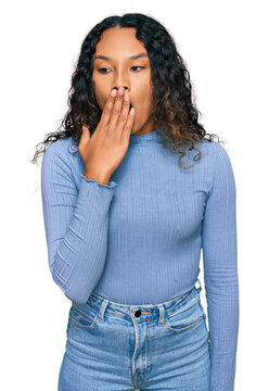 Young hispanic woman with curly hair wearing casual clothes bored yawning tired covering mouth with hand. restless and sleepiness.