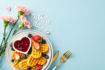 Mother's Day breakfast table: top view heart waffles, strawberries, blueberries, sweet syrup,...
