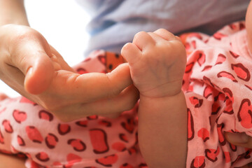 mother fingers holding newborn baby fingers happy