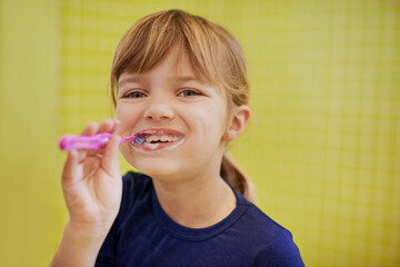 Girl, portrait or child in studio brushing teeth with smile for development isolated on yellow background. Morning, learn or kid cleaning mouth with toothbrush for dental or oral health for wellness