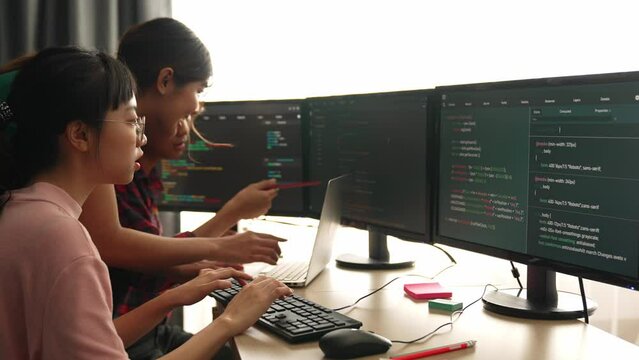 Slow motion back end software developer engineer for computer programming working together on debugging writing computing code, solving complex algorithms display on monitor in office. Burgeoning