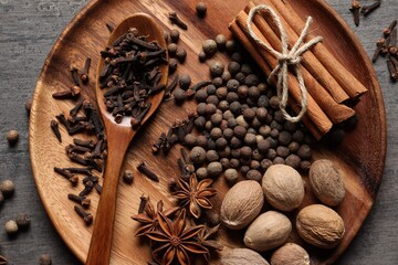 Different spices and nuts on gray table, top view