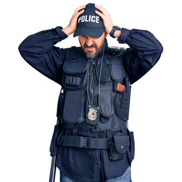 Young handsome man wearing police uniform suffering from headache desperate and stressed because pain and migraine. hands on head.