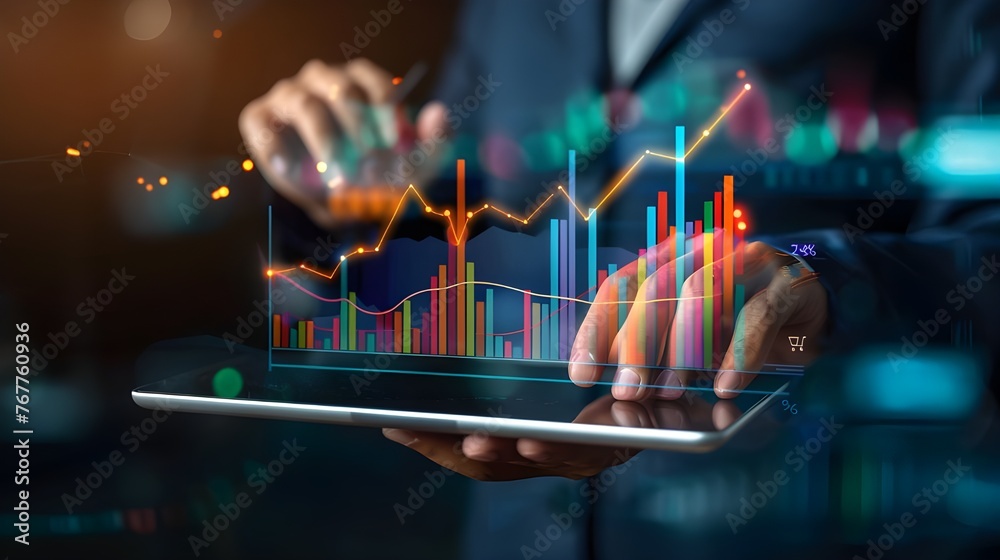 Poster Businessman holding a tablet displaying a digital stock market graph and chart on blur background.