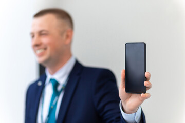 Handsome European Businessman Showing Smartphone With Black Screen At Camera.