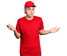 Young caucasian boy with ears dilation wearing delivery uniform and cap clueless and confused...