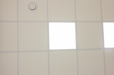 White ceiling with PVC tiles and lighting, bottom view