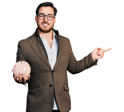 Young hispanic man holding piggy bank smiling happy pointing with hand and finger to the side