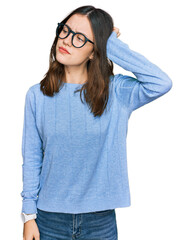 Young beautiful woman wearing casual clothes and glasses confuse and wondering about question....
