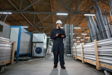 Fototapeta premium Factory worker is indoors with hard hat