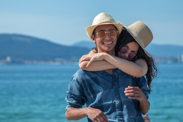 happy young couple hugging on the beach
