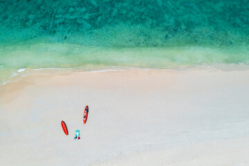Aerial top view of sandy white beach with two orange canoe, and sea water is clear as the emerald color. in the summer season