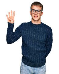 Fototapeta premium Young blond man wearing casual clothes and glasses showing and pointing up with fingers number four while smiling confident and happy.