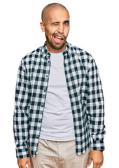 Hispanic adult man wearing casual clothes winking looking at the camera with sexy expression, cheerful and happy face.