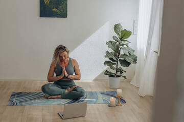 A 50-year-old woman doing online yoga at home