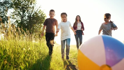 family of children play with a ball in the park. children dream: play soccer in park, running fast and happy. having fun playing with a ball. Kid dream team. family sunset playing in a park - 767790122